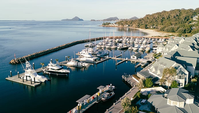 d'Albora Marinas man and woman standing on dock waving to another man and woman standing on cruiser yacht