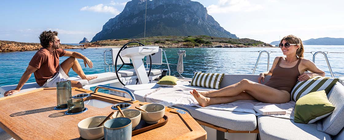 Man and woman sitting on deck of Beneteau Oceanis 52 yacht
