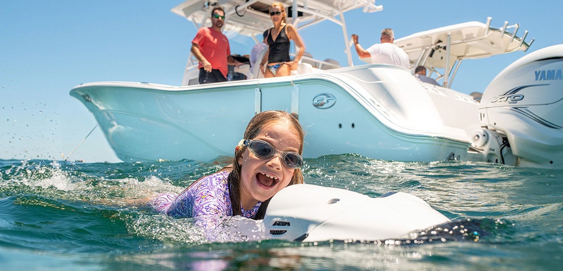Girl having fun on seabob next to boat