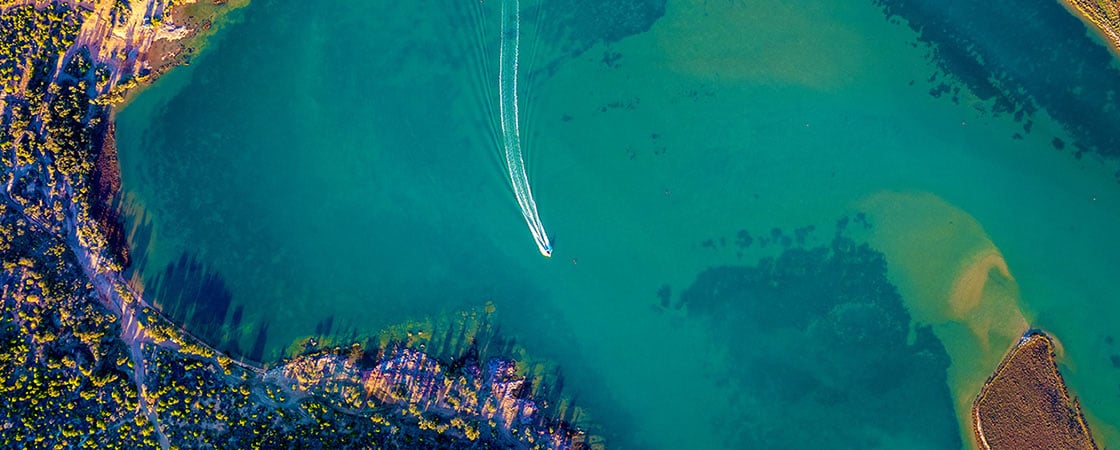Birds eye view of boat moving through river