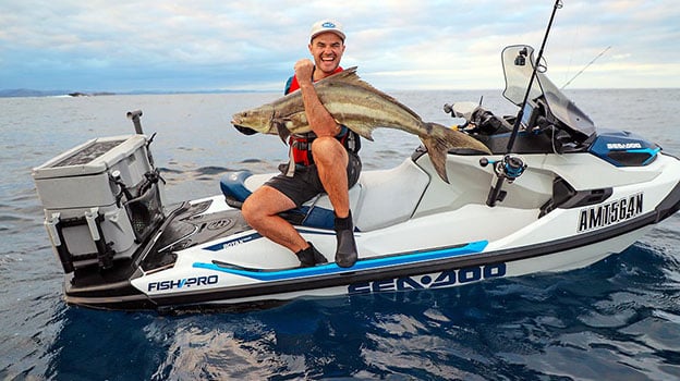 Man catching a cobria off a Sea Doo Fishpro